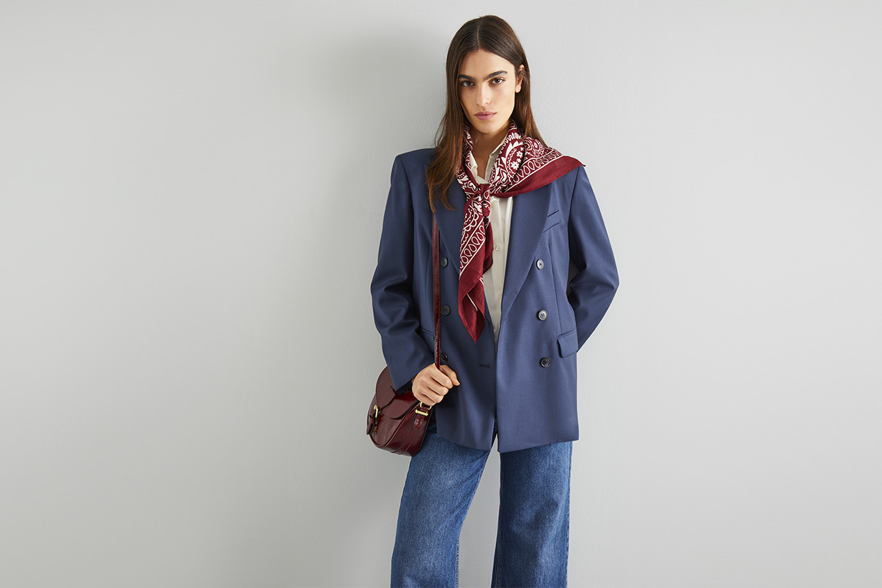 Modella indossa giacca blu con denim e camicia bianca.